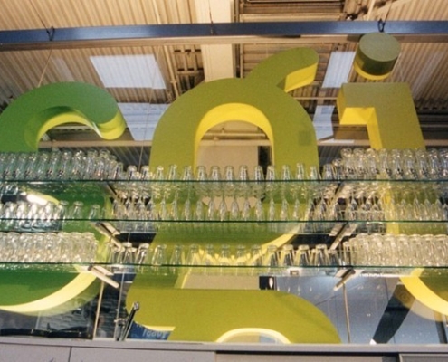Weit überspannendes Gläserregal mit Glasfachböden vor 3 Meter hohen 3-D Buchstaben